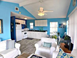 een keuken met blauwe muren en witte meubels in een woonkamer bij Fun in the Sun! Cozy Beach Pad, Gulf Views and Easy Access to the Sand! in Surfside Beach