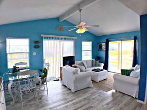een woonkamer met blauwe muren en witte meubels bij Fun in the Sun! Cozy Beach Pad, Gulf Views and Easy Access to the Sand! in Surfside Beach