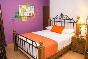 1 dormitorio con cama y pared púrpura en Hotel Verona, en San Pedro Sula