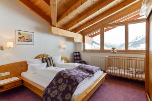 ein Schlafzimmer mit einem Bett und einem großen Fenster in der Unterkunft Fürmesli Appartements in Lech am Arlberg