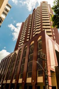 un edificio alto de color marrón con muchas ventanas en Rosenhaus - HomeClub apto grande com Smartv cozinha piscina, en Joinville