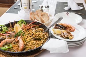a table with a plate of food with seafood and bread at Alcudia Petit - Turismo de Interior in Alcudia