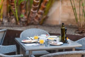 a table with plates of food and a bottle of wine at Alcudia Petit - Turismo de Interior in Alcudia