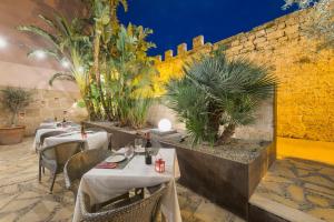 a restaurant with tables and chairs and a wall at Alcudia Petit - Turismo de Interior in Alcudia