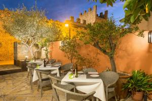 a restaurant with tables and chairs and a wall at Alcudia Petit - Turismo de Interior in Alcudia