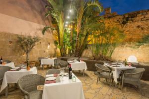 a restaurant with white tables and chairs and plants at Alcudia Petit - Turismo de Interior in Alcudia