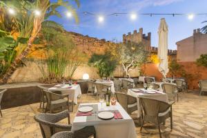 a restaurant with tables and chairs and a wall at Alcudia Petit - Turismo de Interior in Alcudia
