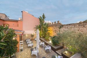 an outdoor patio with tables and chairs and a wall at Alcudia Petit - Turismo de Interior in Alcudia