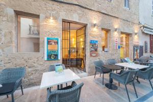 a restaurant with tables and chairs in front of a building at Alcudia Petit - Turismo de Interior in Alcudia