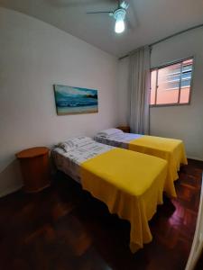 2 camas en una habitación con sábanas amarillas en Yellow Hostel Praia da Costa en Vila Velha