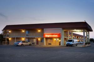 a hotel with two cars parked in a parking lot at Travelodge by Wyndham Winslow in Winslow