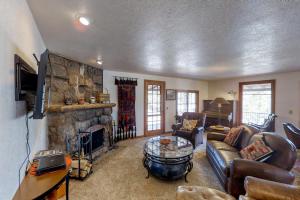 a living room with a couch and a stone fireplace at Historic Wilderness Retreat in Estes Park
