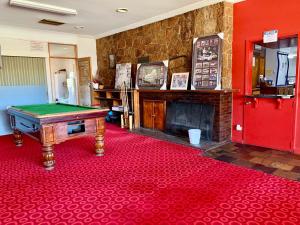 a room with a pool table and a fireplace at Coonalpyn Hotel in Coonalpyn