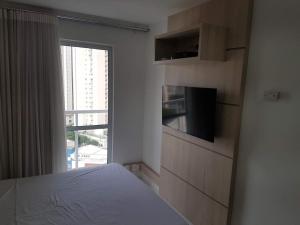 a bedroom with a bed and a large window at Flat mobiliado em região nobre de Goiânia in Goiânia