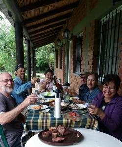 een groep mensen die aan een tafel eten bij posada cerro los nogales in San Agustín de Valle Fértil