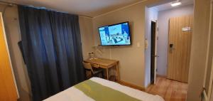 ポハンにあるアップルツリー ホテル 浦項のベッド1台、薄型テレビが備わるホテルルームです。
