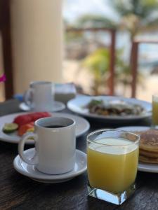- une table avec une tasse de café et un verre de jus d'orange dans l'établissement Paamul Hotel, à Palmul