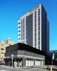 a tall building with the name on top of it at Smile Hotel Utsunomiya Nishiguchi Ekimae in Utsunomiya