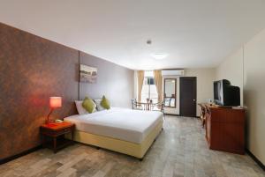 a hotel room with a bed and a television at D-haus Ladprao Residence in Bangkok
