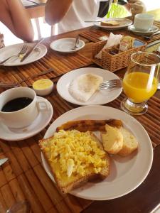 a table with a plate of toast with eggs on it at Pousada Pôr do Sol in Barra Grande