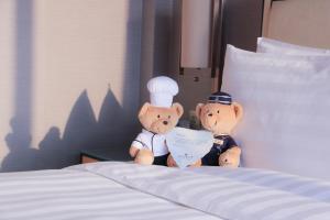 twee teddyberen op een bed bij Shangri-La Xiamen - Seaside Hotel &Free Mini Bar in Xiamen