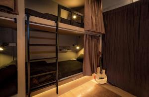a room with two bunk beds with a guitar in it at Mind Day Hostel Khaosan in Bangkok