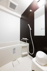 a bathroom with a white toilet and a mirror at Grand Inn Canalside in Fukuoka