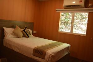 En eller flere senge i et værelse på Shadow Grove Camping & Cabins Kitulgala