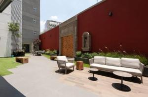 a patio with a couch and chairs next to a building at San Angel Luxury apartment 2BR 2BA 1Parking in Mexico City
