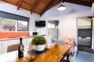 a dining room with a table with a bottle of wine at Gardens Caravan Park in Port Fairy