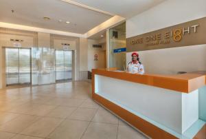 a woman standing behind a counter in a one eighty hotel lobby at 118 Residences by Travovo in George Town +60 photos
