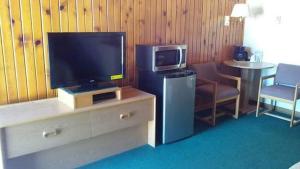 ein Wohnzimmer mit einem TV und einem Tisch mit einem Stuhl in der Unterkunft Meadow Park on 385 in Bridgeport