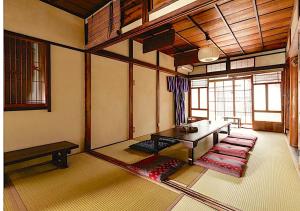 - un salon avec une table et des bancs dans l'établissement ゲストハウス君彩家 kimidoriya, à Osaka