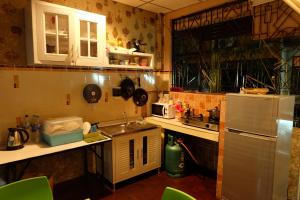 a small kitchen with a sink and a refrigerator at Decordo Hostel in Bangkok