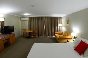 een hotelkamer met een bed en een woonkamer bij Club Inn Motel in West Wyalong