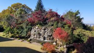 a waterfall in the middle of a park with trees at Okayama International Hotel in Okayama