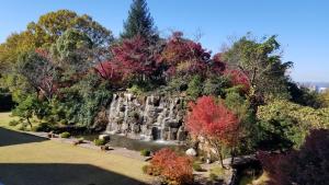 einem Wasserfall inmitten eines Parks mit Bäumen in der Unterkunft Okayama International Hotel in Okayama