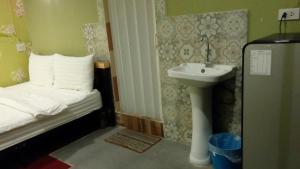 a small bathroom with a bed and a sink at Decordo Hostel in Bangkok
