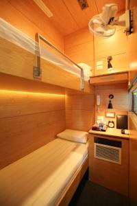 Habitación pequeña con cama y escritorio. en VATC Sleep Pod Terminal 2 en Noi Bai