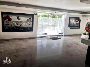 uma sala de estar com uma grande pintura na parede em Hotel Del Valle em Cidade do México
