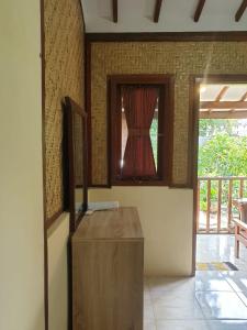 a room with a window and a wooden table at Nita's Homestay Banyuwangi in Banyuwangi