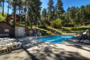 una piscina en un patio con 2 sillas blancas en Powder House Lodge en Keystone