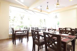 a dining room with wooden tables and chairs at Treebo Trend Ivory House in Nagpur