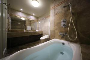 a bathroom with a bath tub and a toilet at Kamakura Park Hotel in Kamakura +47 photos