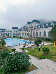 a large white building with a large swimming pool at SSAW Boutique Hotel Lishui Jiarui in Lishui