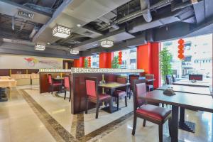 um restaurante com mesas e cadeiras e paredes vermelhas em Sun And Sands Downtown em Dubai