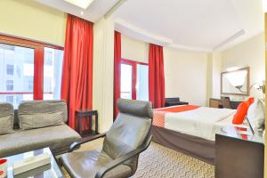 Un dormitorio con una cama, un sofá y una silla. en Sun And Sands Downtown, en Dubái