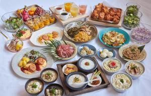 una mesa con muchos platos de comida. en Lequ Okinawa Chatan Spa ＆ Resort, en Chatan