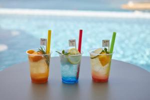 北谷町的住宿－Lequ Okinawa Chatan Spa ＆ Resort，坐在桌子上的三杯鸡尾酒