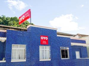 um edifício azul com dois sinais vermelhos em OYO Hotel Lindoia, Petropolis em Petrópolis